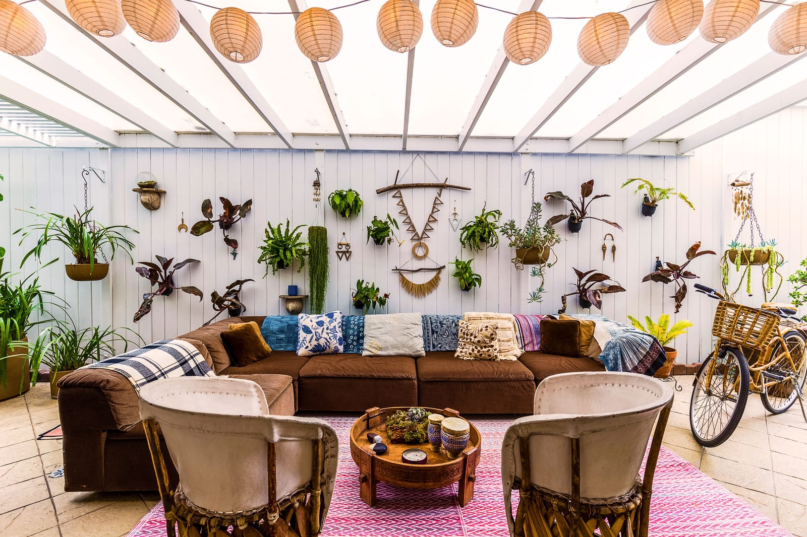outdoor lounge area with living plant wall lanterns and bohemian sectional sofa